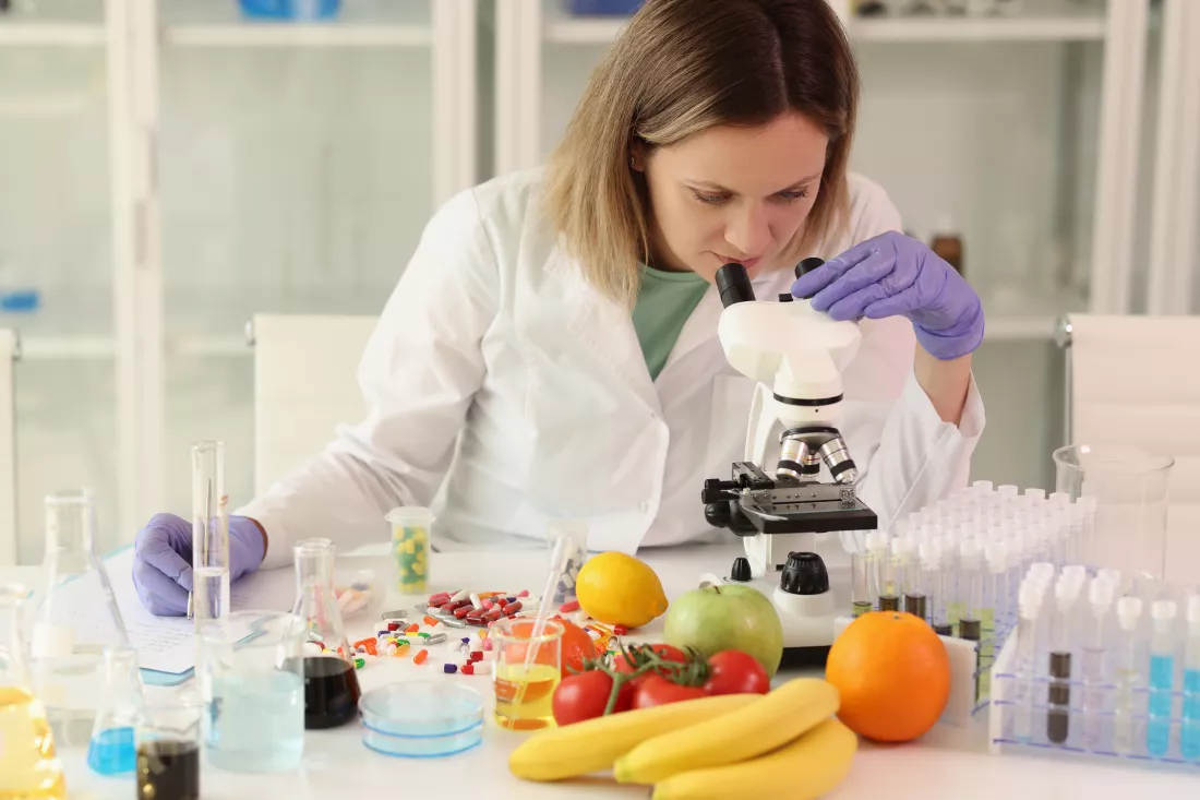 female-scientist-with-microscope-test-tubes-laboratory-glassware-reagents-examining-many
